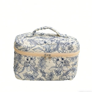 Quilted floral cotton makeup bag with dark blue botanical print and sturdy top handle