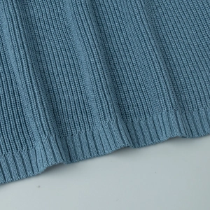 Close-up of the light blue ribbed knit texture and hem detail of the dress