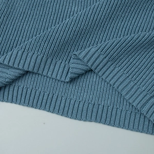 Macro shot of blue rib-knit dress hemline showcasing premium stitching and fabric texture