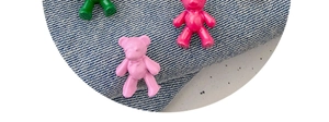 Detailed close-up of cute bear-shaped waist tightener buttons for jeans in three colors