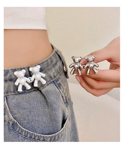 Detail of cute bear-shaped metal waist adjusters for denim jeans in silver and white