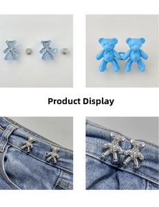 Detail of bear waist adjusters showing blue and silver metal buckles on denim jeans