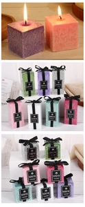 Detailed view of square ice crystal texture candles with black ribbons on wooden surface