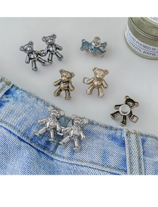 Detailed close-up of metallic bear-shaped waist tightener buttons for denim jeans