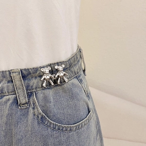 Silver bear-shaped waist tightener buttons for jeans adjustment on a model side view