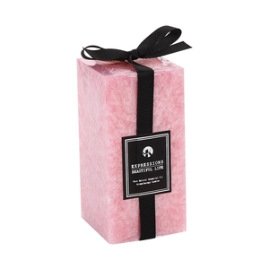 Pink pillar scented candle with ice crystal texture and a black satin bow on white background