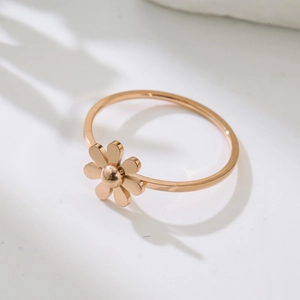 Elegant rose gold daisy ring featuring a minimalist flower design on a white surface