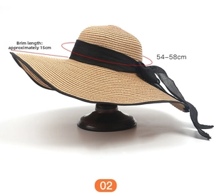 Detail of 15cm wide brim straw sun hat with black mesh bow and woven texture