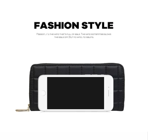 Detail view of black quilted long wallet with golden zipper compared with a smartphone