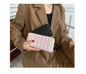 Close-up of quilted PU leather long wallets in black and pink with gold zippers