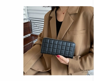 Close-up of quilted black PU leather women's long wallet with gold zipper detail