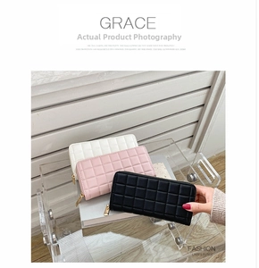Detailed view of quilted long wallets in white, pink, and black with golden zippers