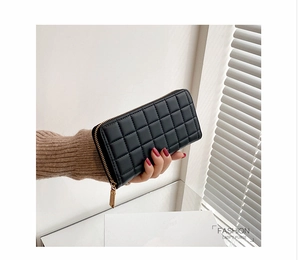 Detail of black quilted PU leather long wallet for women with golden zipper hardware