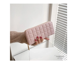 Detail of pink quilted PU leather long wallet with golden zipper held by a woman