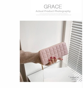 Lifestyle shot of a stylish pink quilted long wallet for women with golden zipper detail