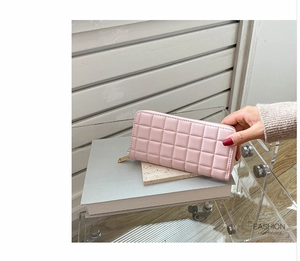 Pink quilted PU leather wallet detail featuring gold zipper on an aesthetic display stand