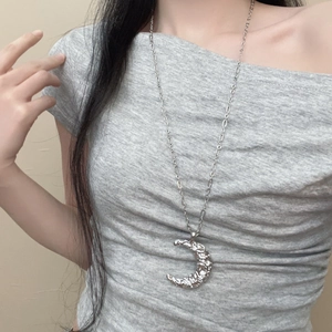 Collier long argenté avec pendentif croissant de lune texturé au design minimaliste