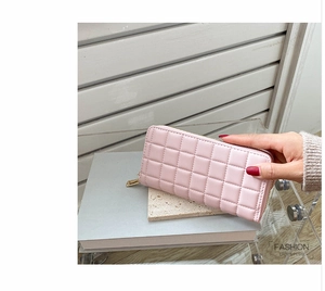 Pink checkered quilted long wallet for women with golden zipper detail held in hand