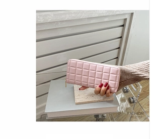 Close-up of pink long quilted PU leather wallet with zipper closure and gold puller