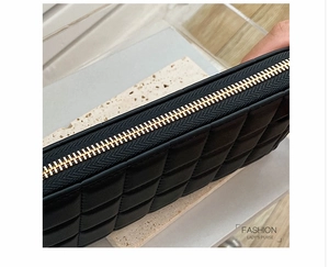 Detail of black quilted leather lady's purse with premium gold zipper and metal hardware