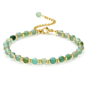 Macro detail of green beaded bracelet with polished gold spacers and lobster clasp