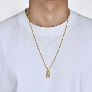 Close-up of a minimalist gold oval pendant necklace on a model wearing white t-shirt