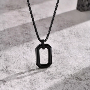 Close-up of a black geometric octagonal pendant on a sleek box chain for men