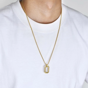 Close-up of a golden rectangular hollow geometric pendant on a minimalist chain