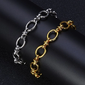 Close-up of industrial-style gold and silver polished oval link chain bracelets