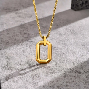 Macro view of golden hollow rectangular pendant with polished box chain on stone surface