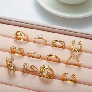 Détail de 12 bagues dorées ornées de zircons micro-pave dans un coffret à bijoux rose