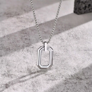Detailed view of silver octagonal hollow pendant on a square link chain necklace
