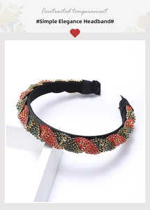Detail view of a luxury wide headband featuring red, green, and gold rhinestone weaving