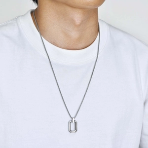 Close-up of a silver stainless steel geometric octagon pendant on a male model neck
