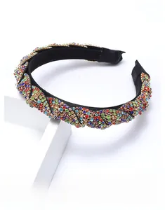 Close-up of twisted colorful rhinestone headband with vibrant gems on black frame