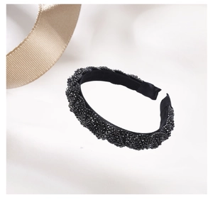 Detail view of a black twisted headband featuring shimmering micro-beads and elegant texture