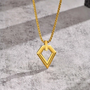 Detail of a polished gold geometric rhombus pendant on a fine box chain necklace