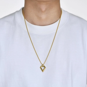 Close-up of a men's geometric hollow rhombus pendant on a gold stainless steel chain