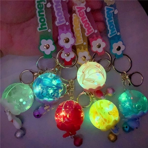 Luminous keychain featuring glowing spheres with dried flowers, glitter, and honey strap