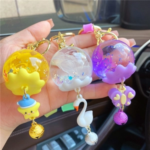 Close-up of creative liquid sand charms with swan, butterfly, and metal bells