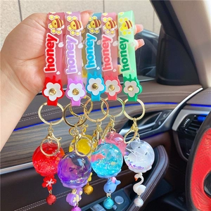 Close-up of colorful liquid floating keychains with glitter and dried flowers