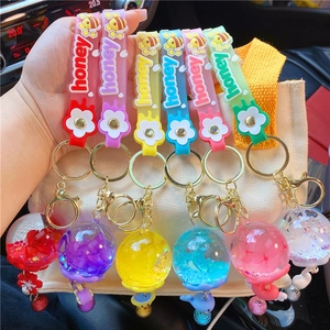 Close-up of candy-colored honey bee silicone wristband keychains with floral liquid baubles