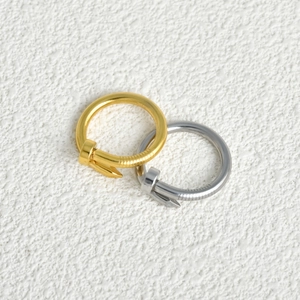 Macro detail of gold and silver nail rings showing textured bands and polished finish