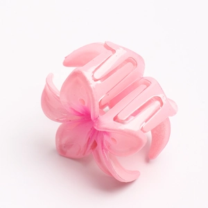 Detail of a glossy pink gradient frangipani flower hair claw clip with metal spring