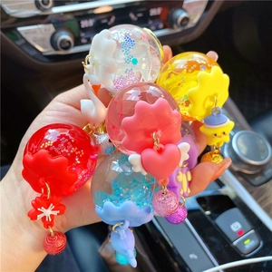 Close-up of assorted glow-in-the-dark dried flower swan and whale liquid glitter keychains