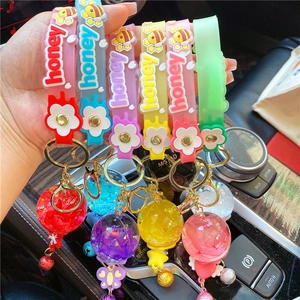 Close-up of colorful honey silicone hand straps with dried flower resin balls and bells