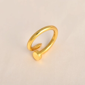 Macro detail of gold nail ring showing textured grooves and polished mirror finish