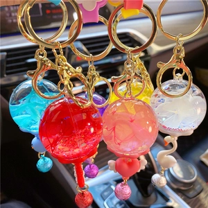 Close-up of creative liquid keychains with colorful bells, glitter, and swan charms