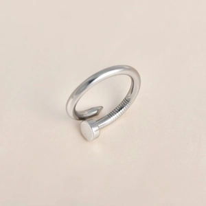 Macro detail of silver nail ring with intricate screw threads and polished finish