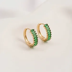 Detailed macro view of 14K gold plated hoop earrings with emerald green zircon inlay